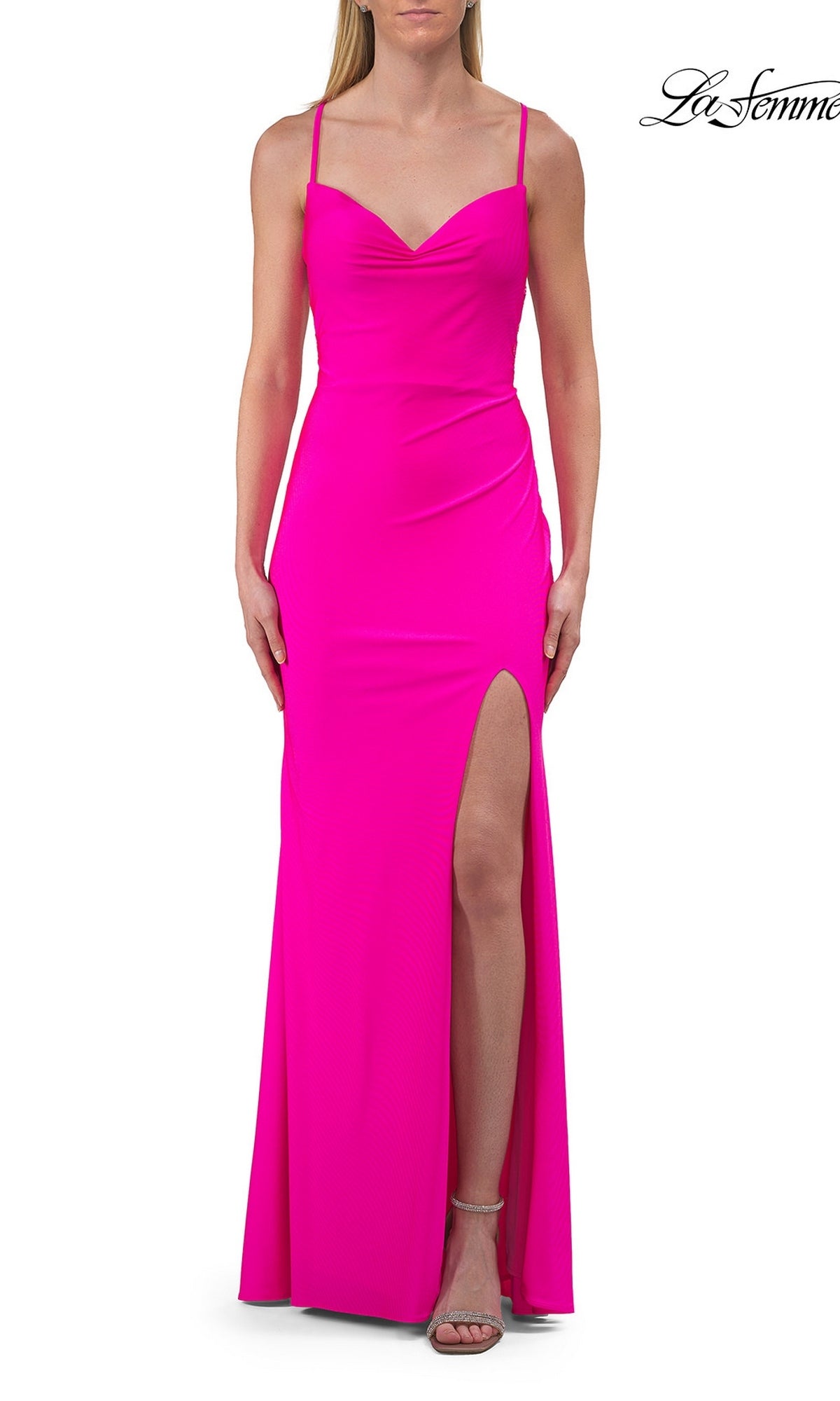 A woman wearing a hot fuchsia La Femme 33553 cowl-neck strappy long prom dress with a high slit on the left side, standing against a white background.